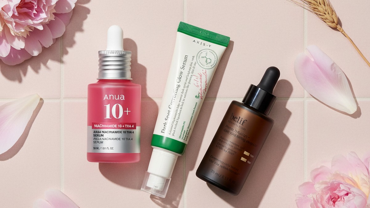 Bottle of Korean brightening serum with dropper on white marble, soft side lighting